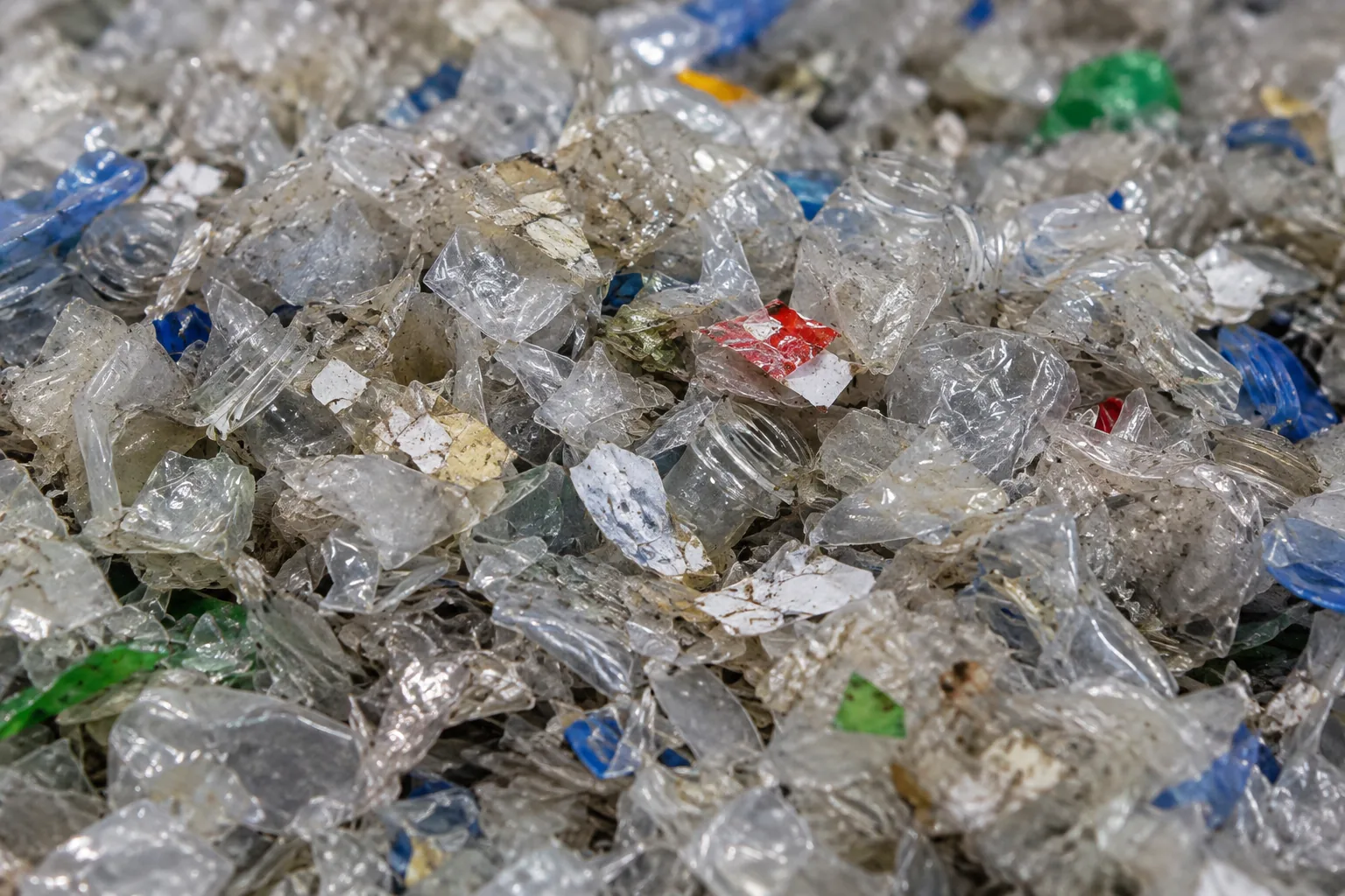 AI concept image of plastic packaging flakes with adhesive residue and oily grime.